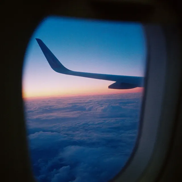 An aeroplane wing at dusk through the window