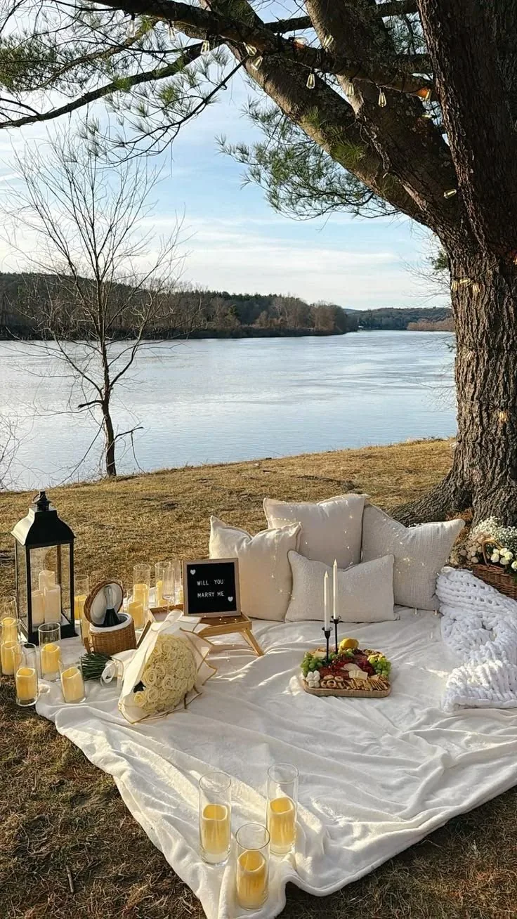 Proposal picnic setup with candles, florals and a marry me sign