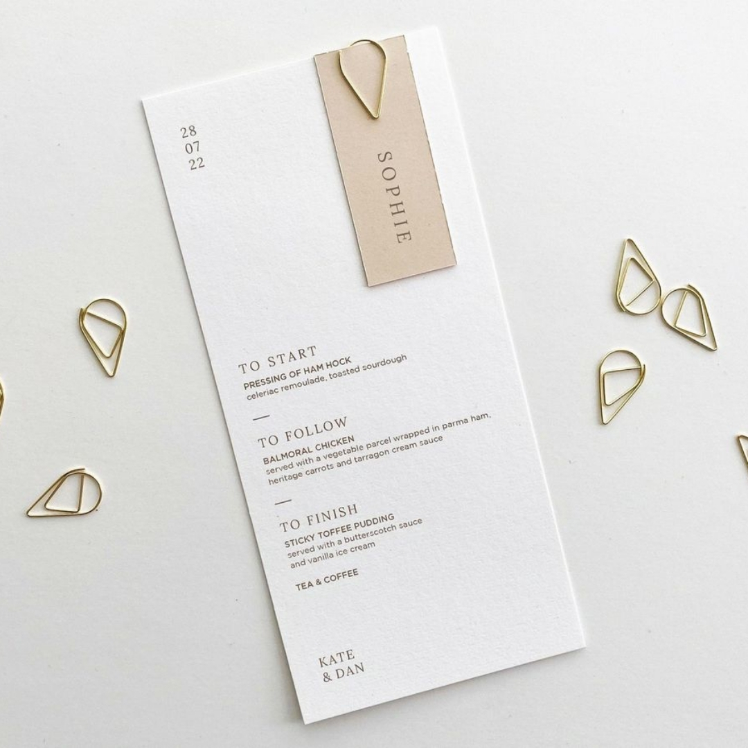 Menu and name tag joined with a gold paperclip