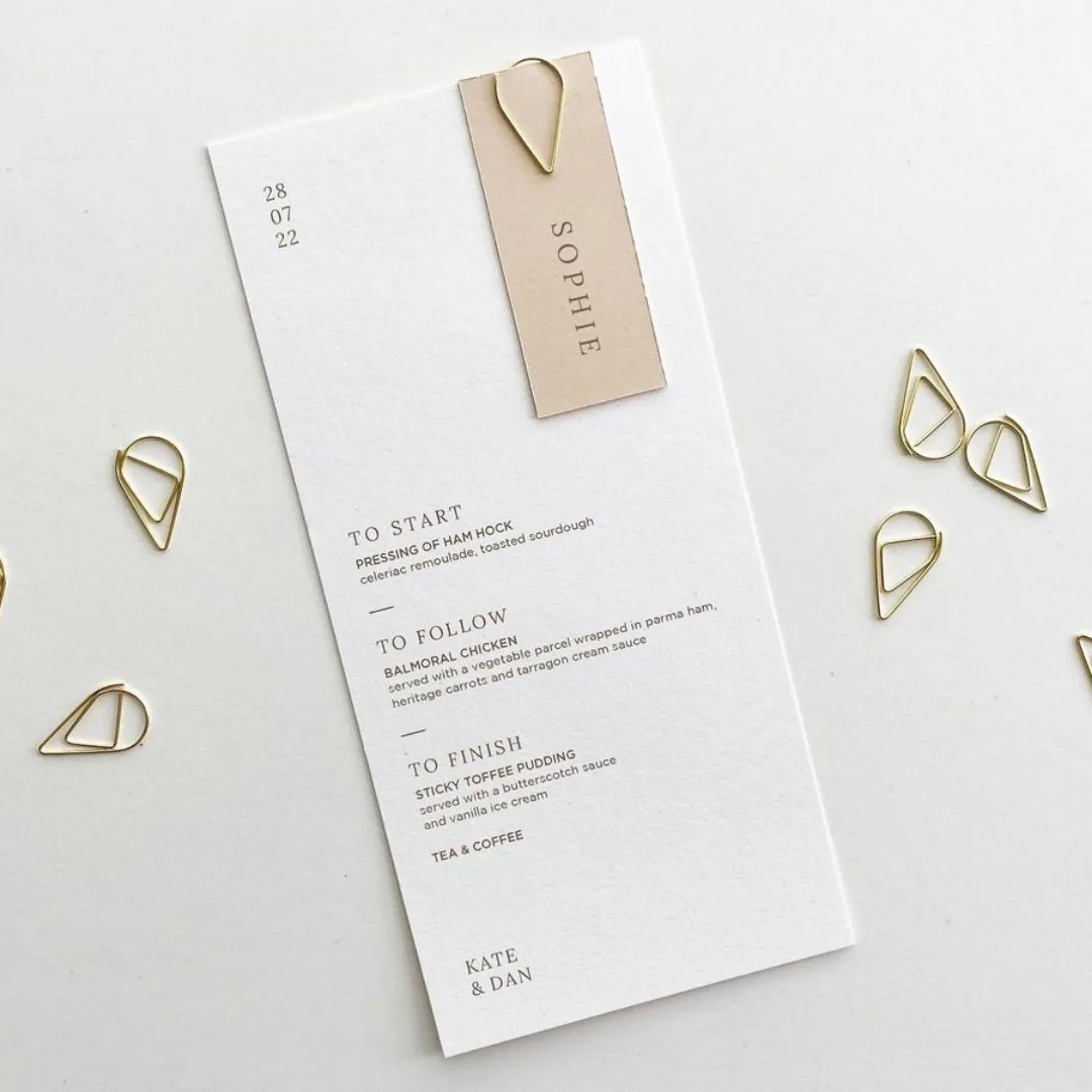 Menu and name tag joined with a gold paperclip