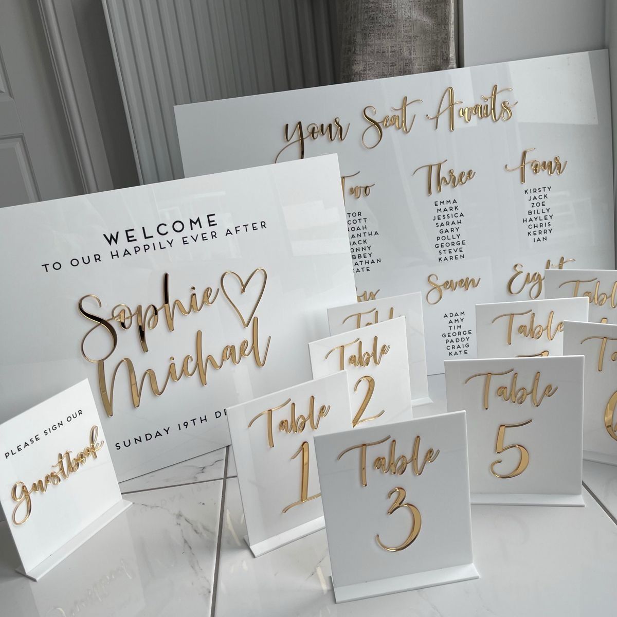 Acrylic welcome sign, seating chart and gold table numbers