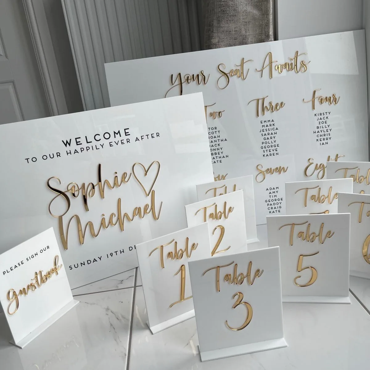 Acrylic welcome sign, seating chart and gold table numbers